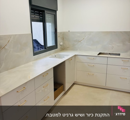 משטחי שיש לבנים במטבח מודרני עם ארונות